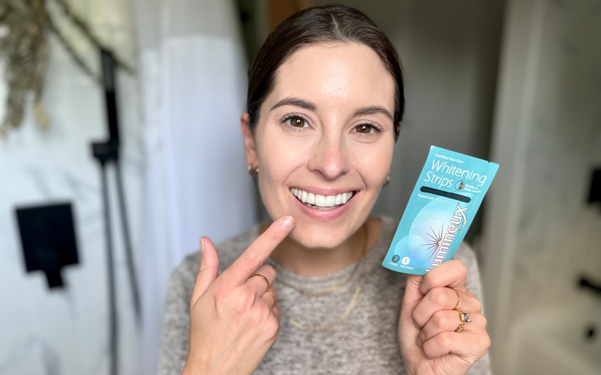 Woman pointing to the results of her Lumineux Whitening Strips, one of the top best beauty products of 2023.