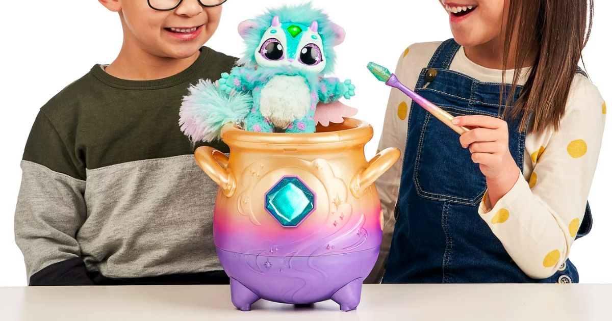 two kids playing with a Magic Mixies Magical Misting Cauldron with Interactive Blue Plush Toy