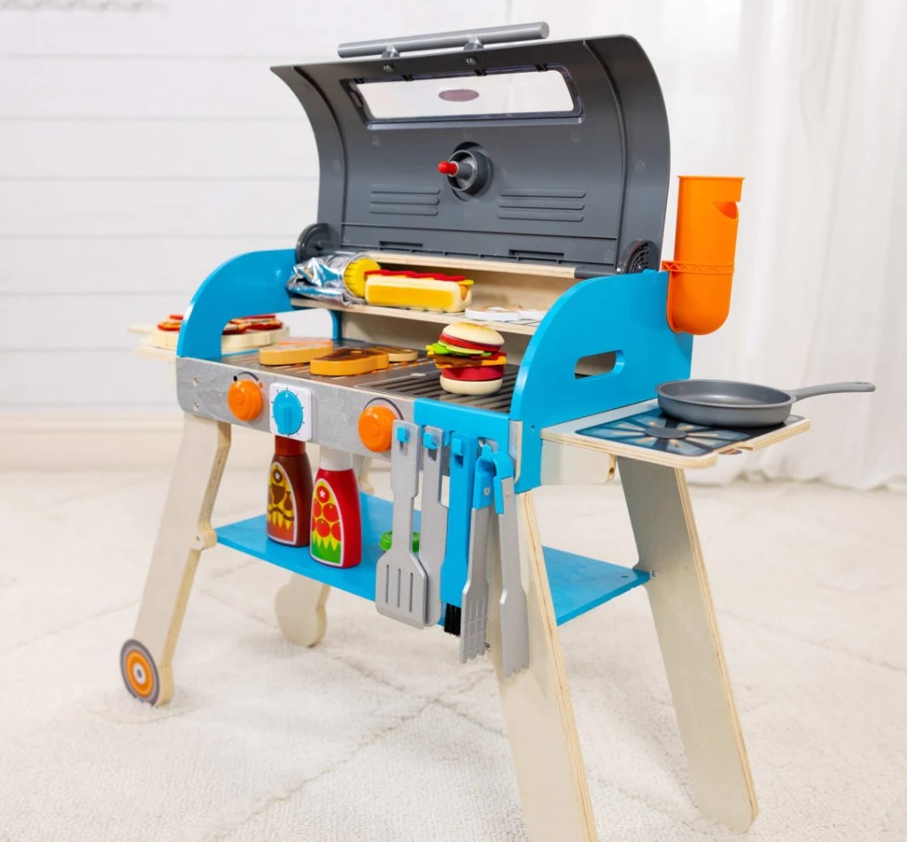 Wooden grill playset with food on it