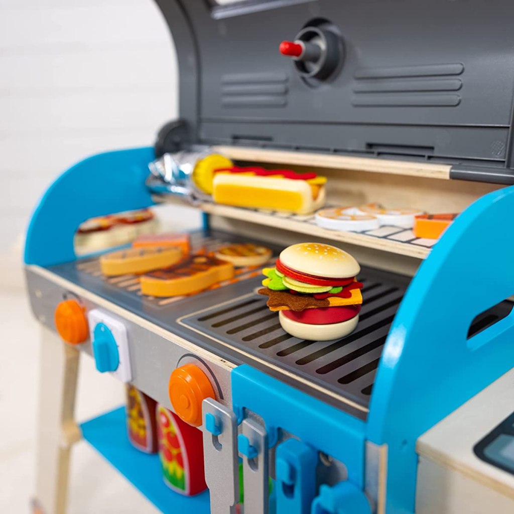 Wooden grill playset with food on it