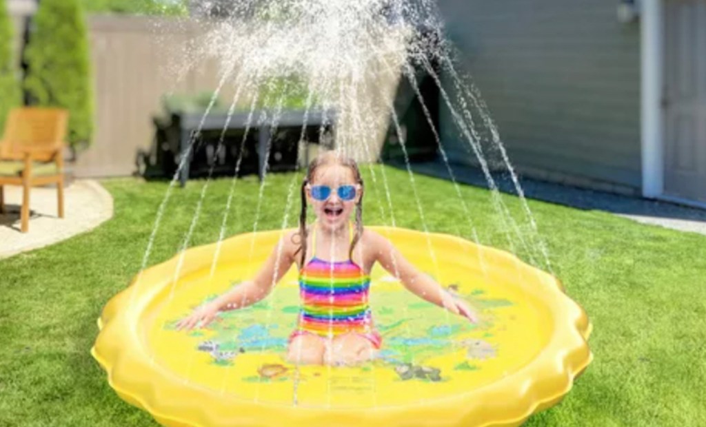 round yellow splash pad with kid sitting in the middle with goggles