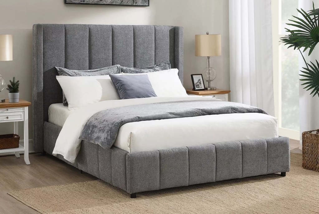Grey upholstered bed with white and grey bedding