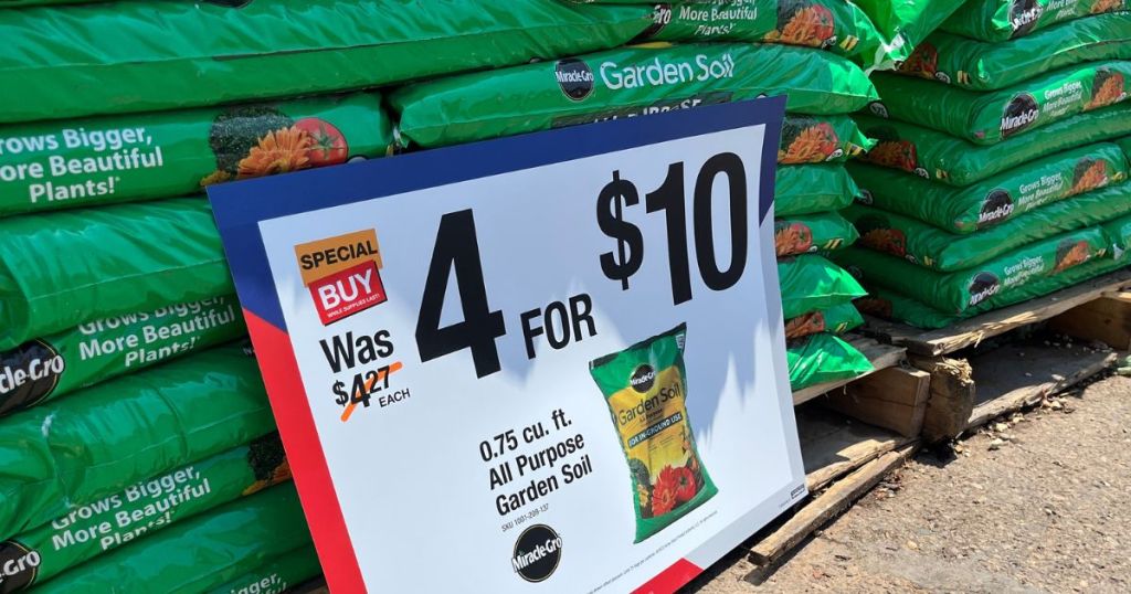 Stacks of bags of Miracle Gro soil at Home depot with sale sign for 4 for $10