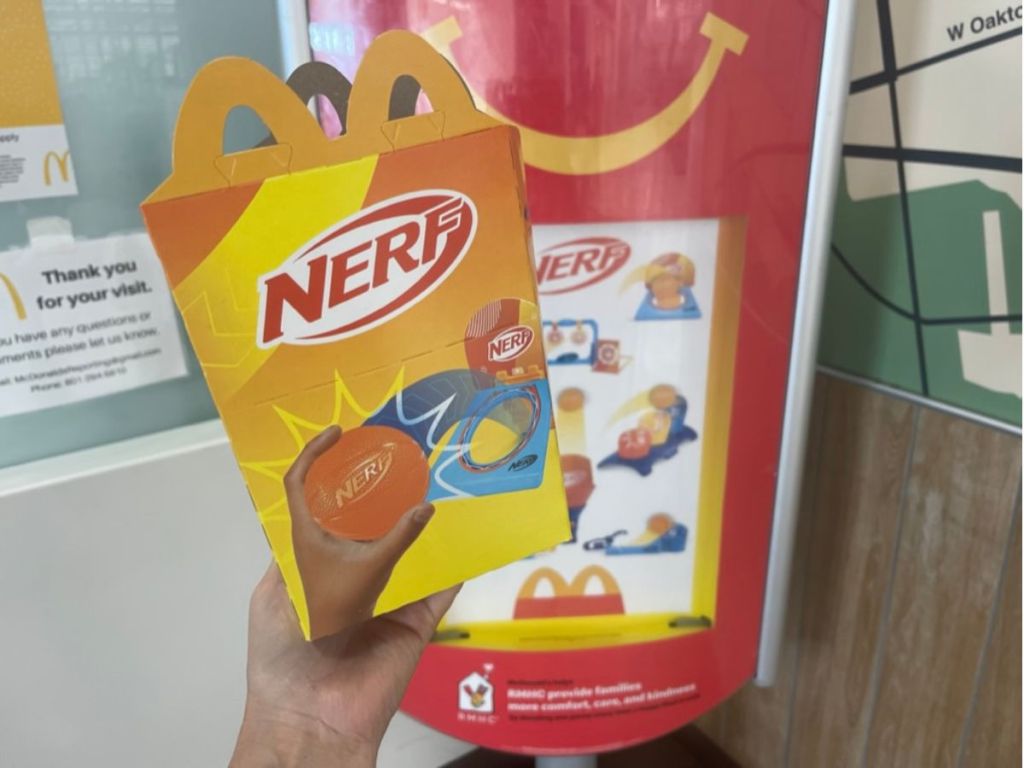 A hand holding a Nerf Happy Meal box 