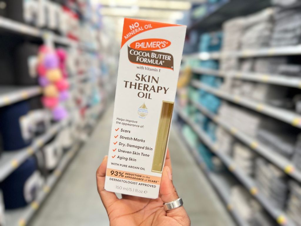 A hand holding Palmer's Skin Therapy Oil