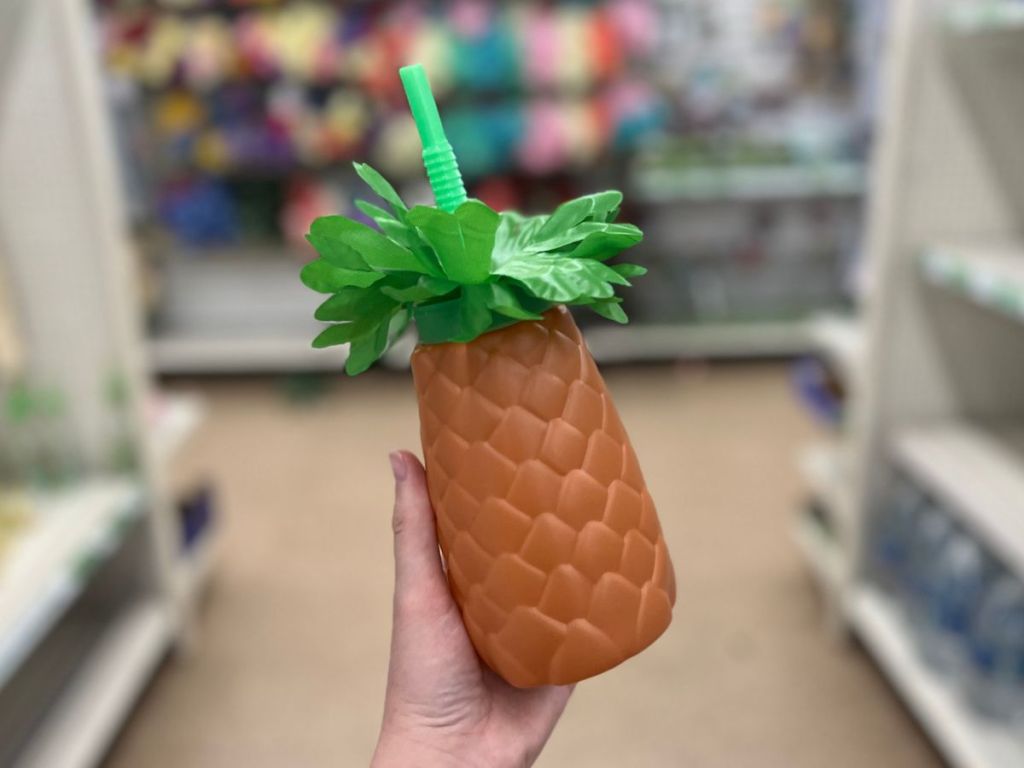 Pineapple sipper with lid and straw and fluffy leaf foliage at top