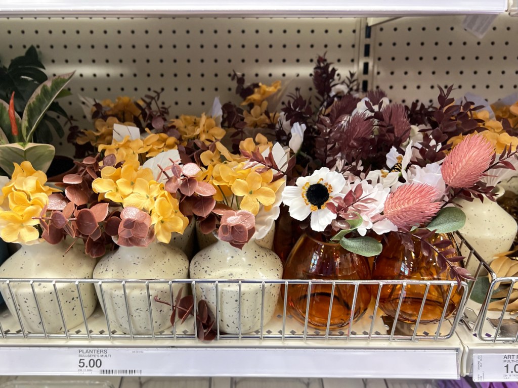 shelf full of fake flowers in vases