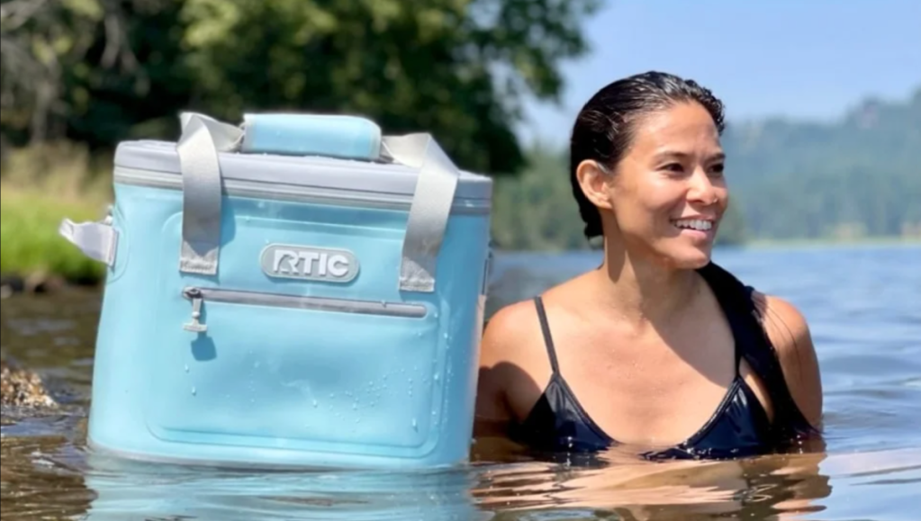 Woman floating in water with her RTIC Soft Cooler Bag