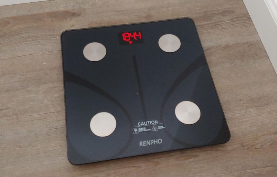 Black digital scale with grey circles in the four corners