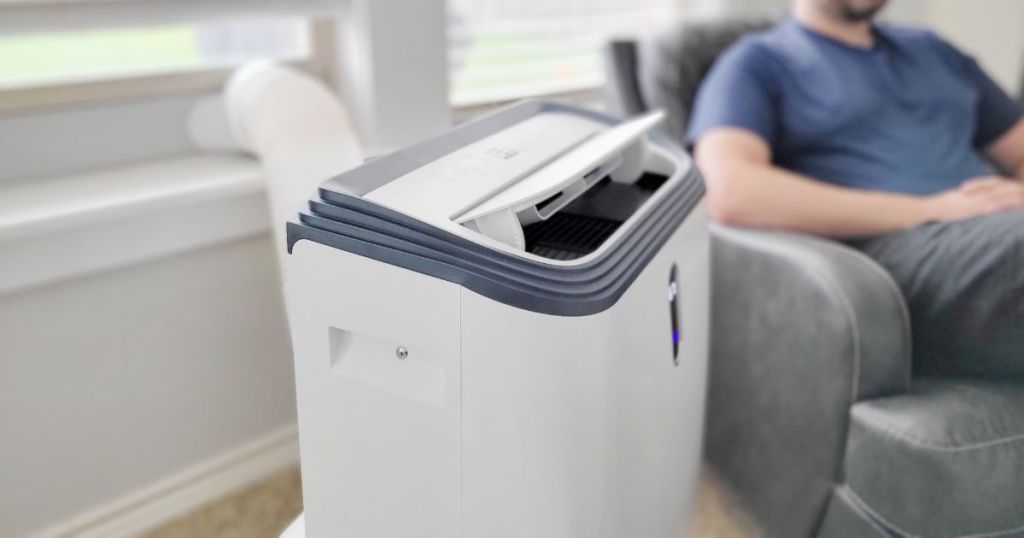 AC unit in living room next to man sitting in recliner