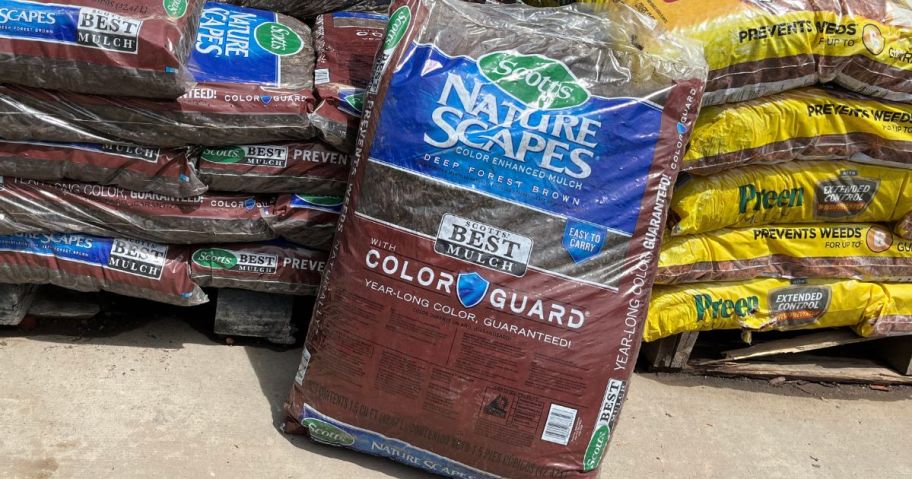 Bag of mulch leaning against pallets of mulch