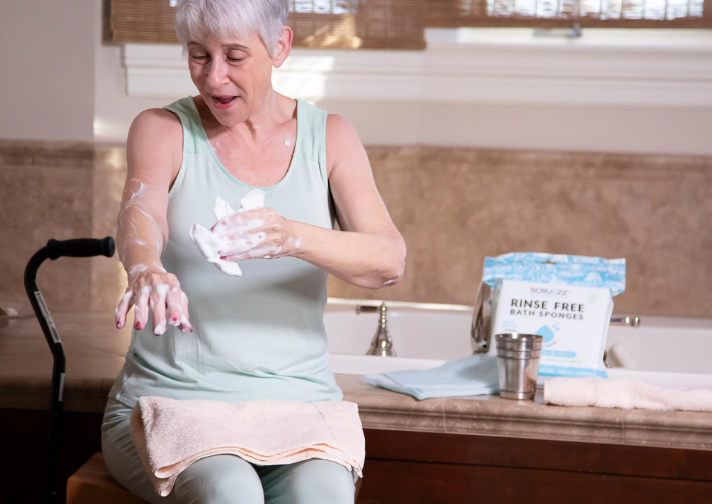 Senior woman using the ScrubZZ rinse-free shower sponge to clean up