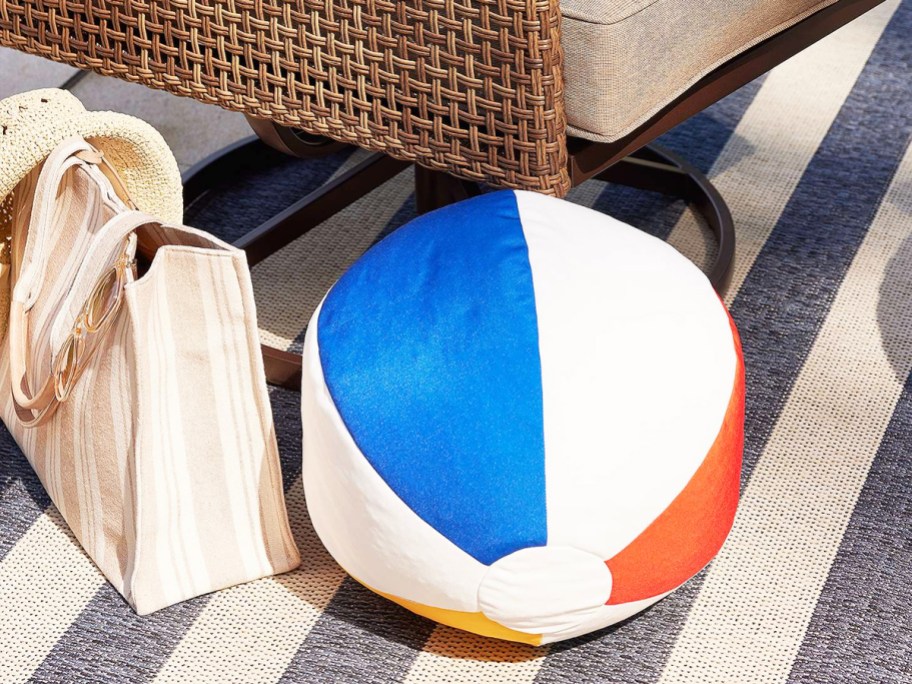 beach ball throw pillow on ground near patio chair
