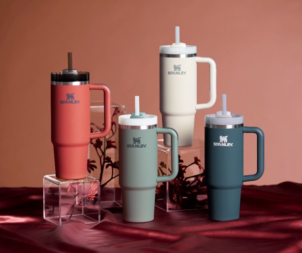 Four Stanley tumblers sitting on a red fabric