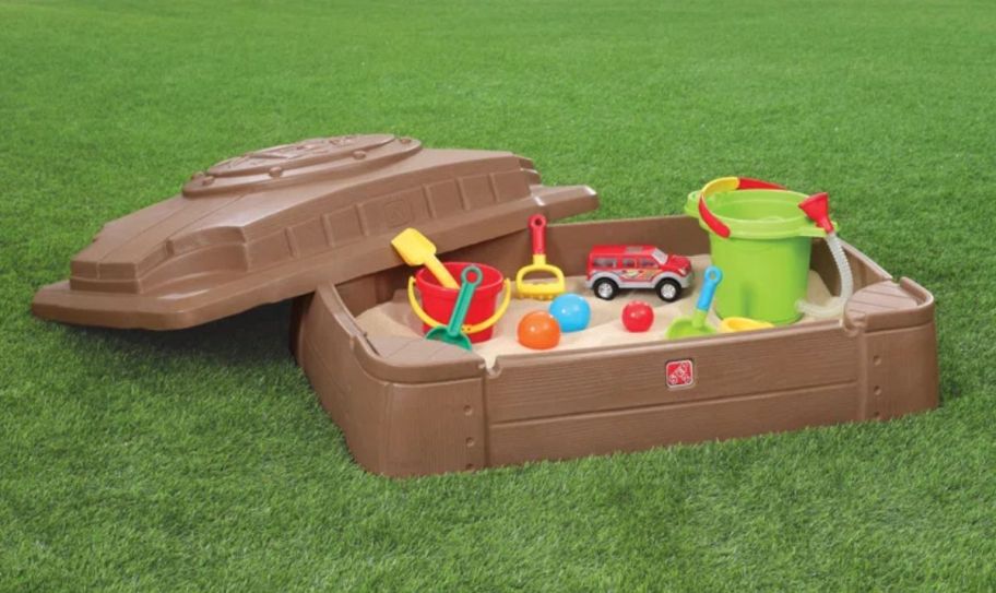 a kids sandbox filled with sand and toys.