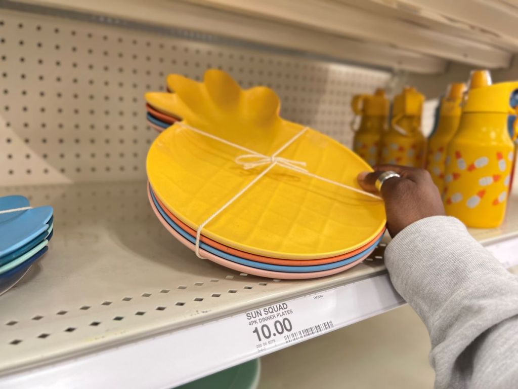 hand holding a pack of pineapple shaped plates