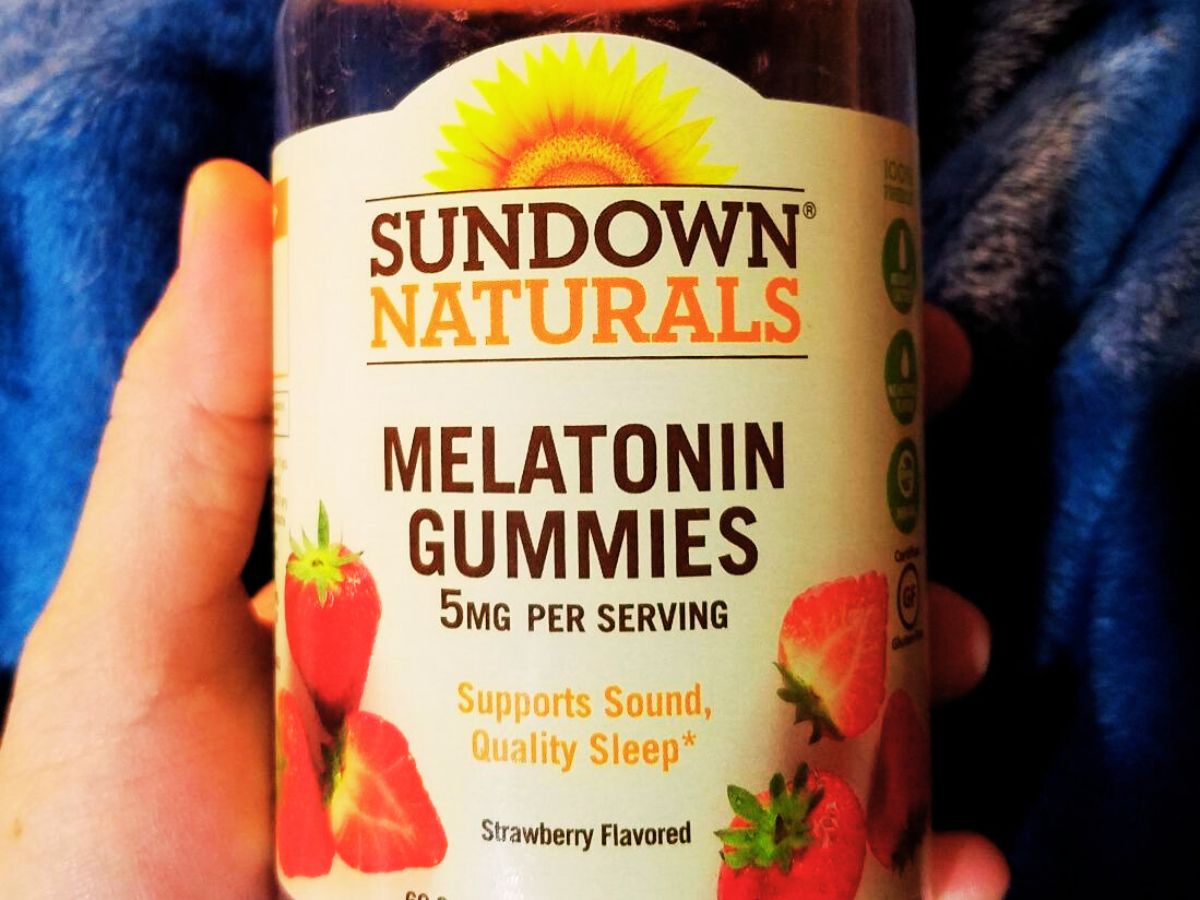 Hand holding bottle of Sundown Naturals Melatonin Gummies