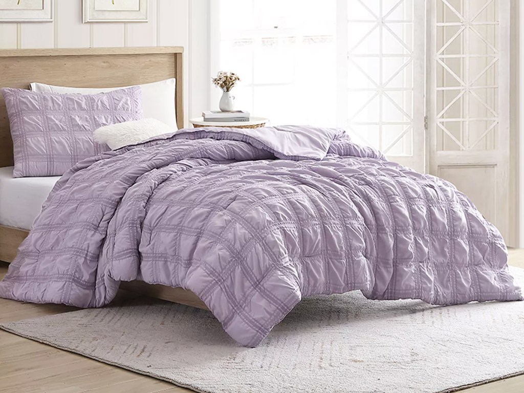 purple quilted comforter set on bed