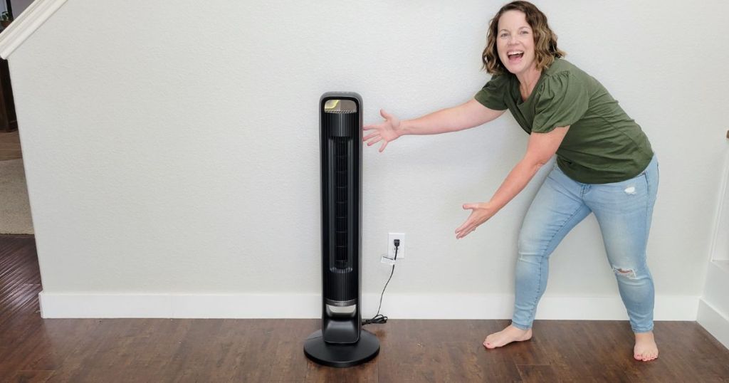 woman pointing at tower fan