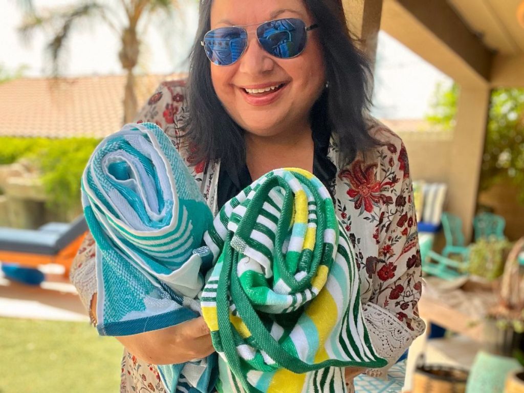 woman holding two beach towels