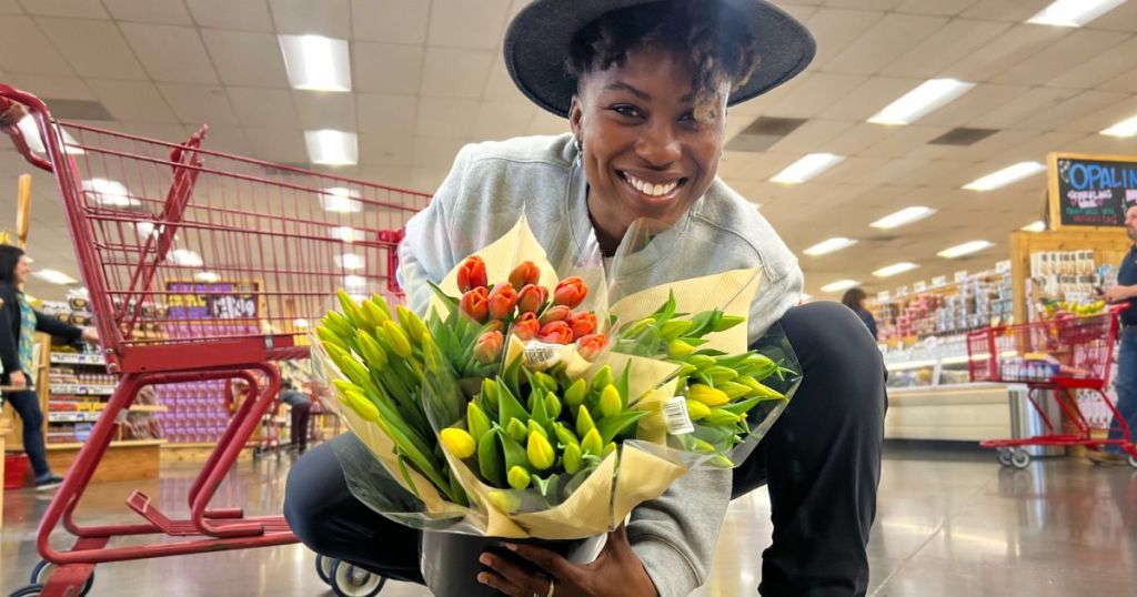 person holding bouquet of colorful tulips in store