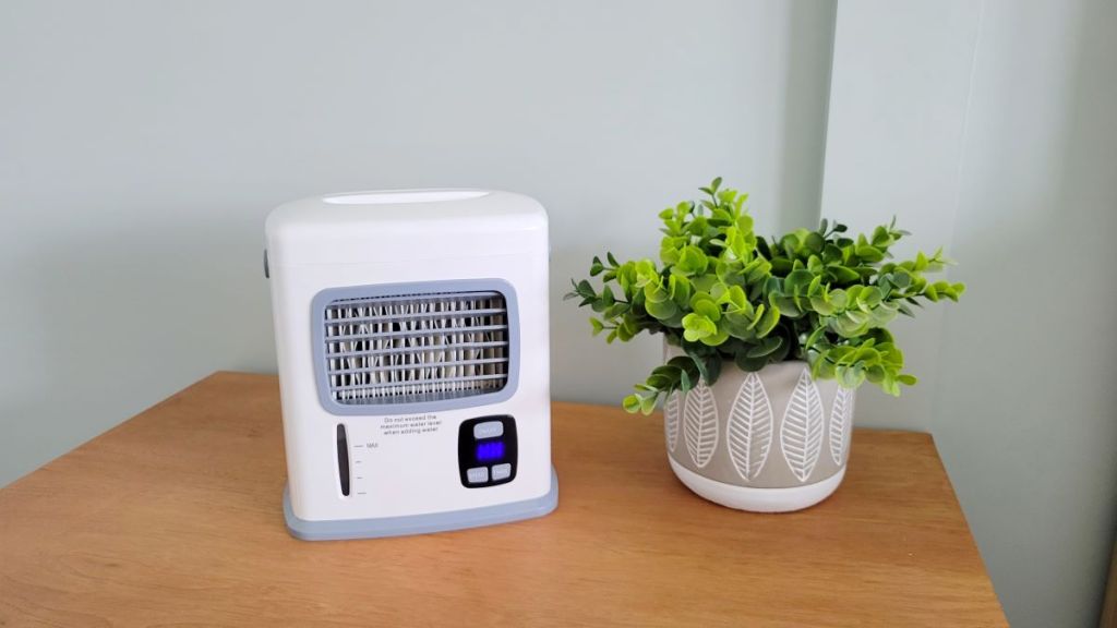 Mini air conditioner sitting on a table by a plant