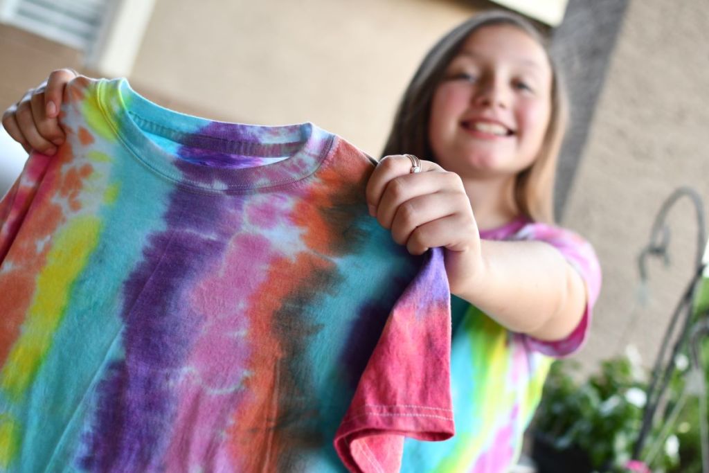 Girl holding a tie-dyed shirt