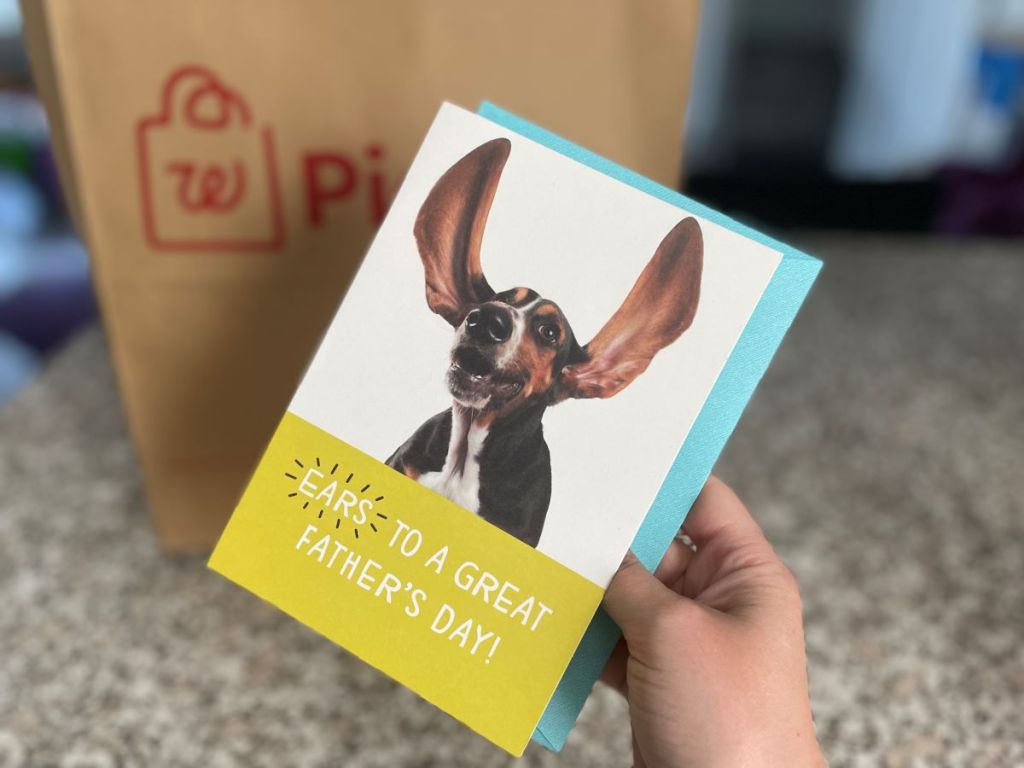Hand holding a Father's Day card with a dog on it