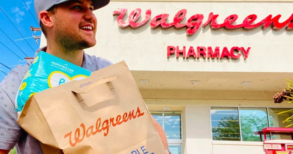 Walgreens store front with man with a walgreens paper bag