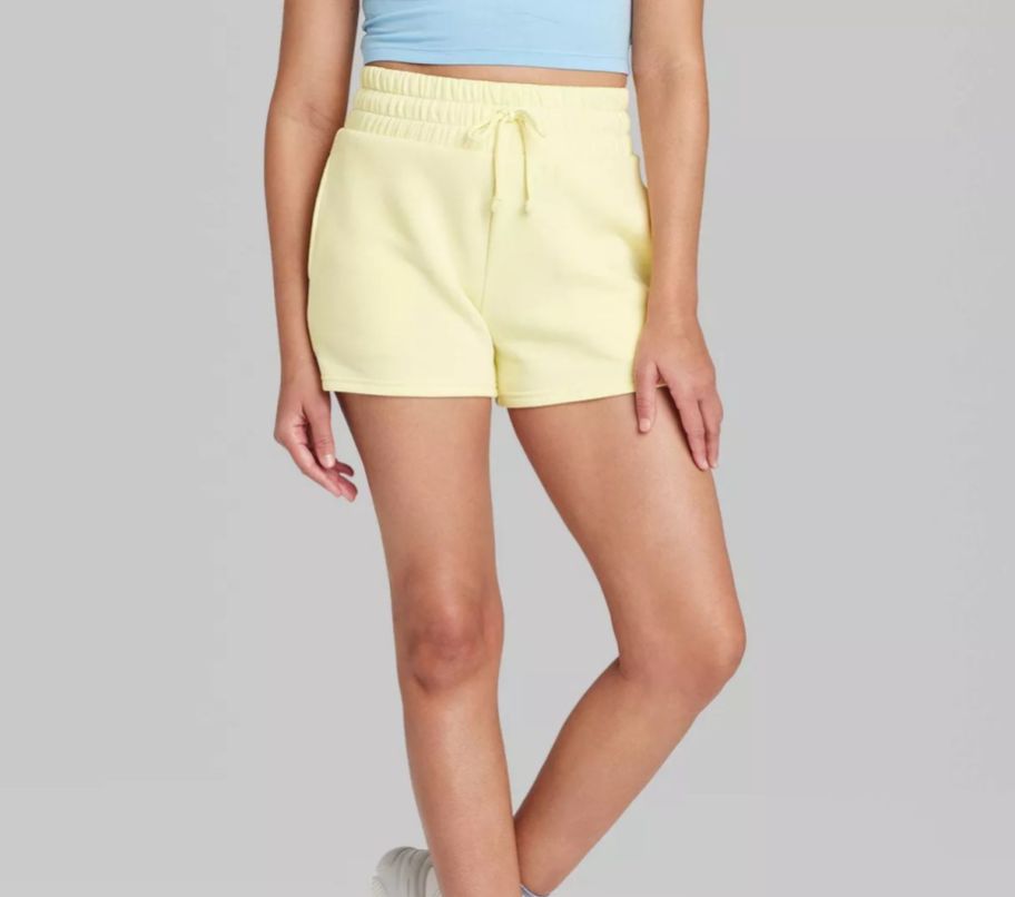 a woman wearing a pair of yellow pull on fleece shorts