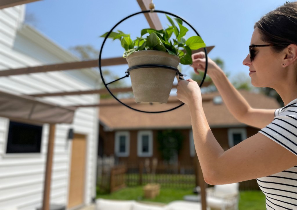 Woman installing a hanging planter from Walmart