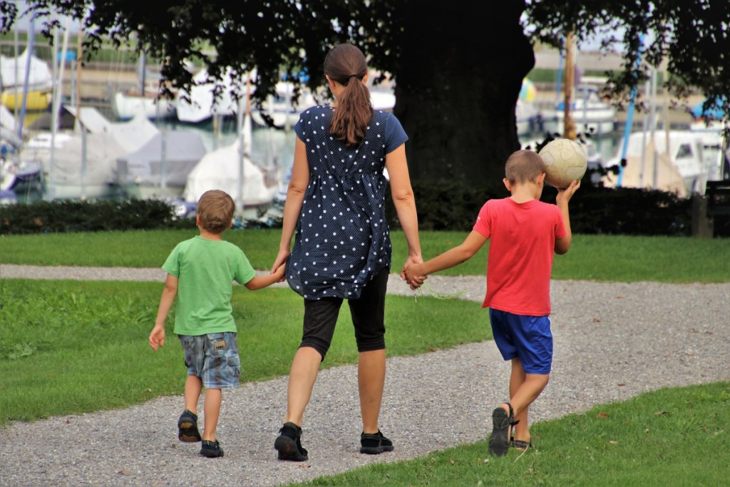 Woman holding hands with her children