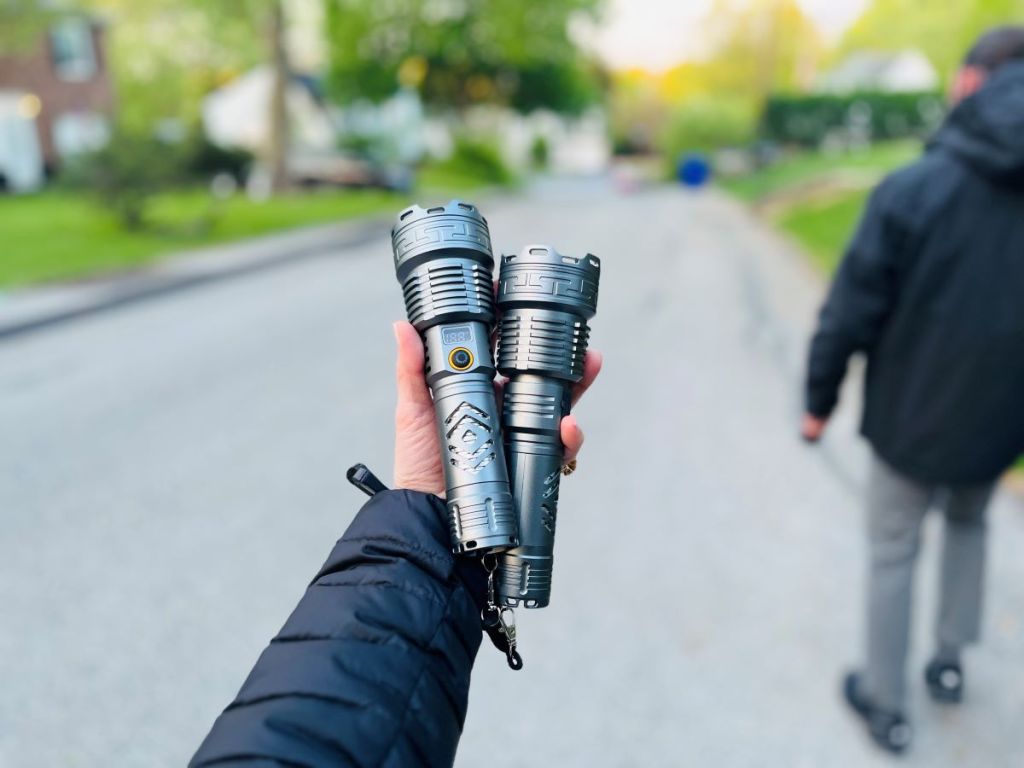 Hand holding two rechargeable flashlights