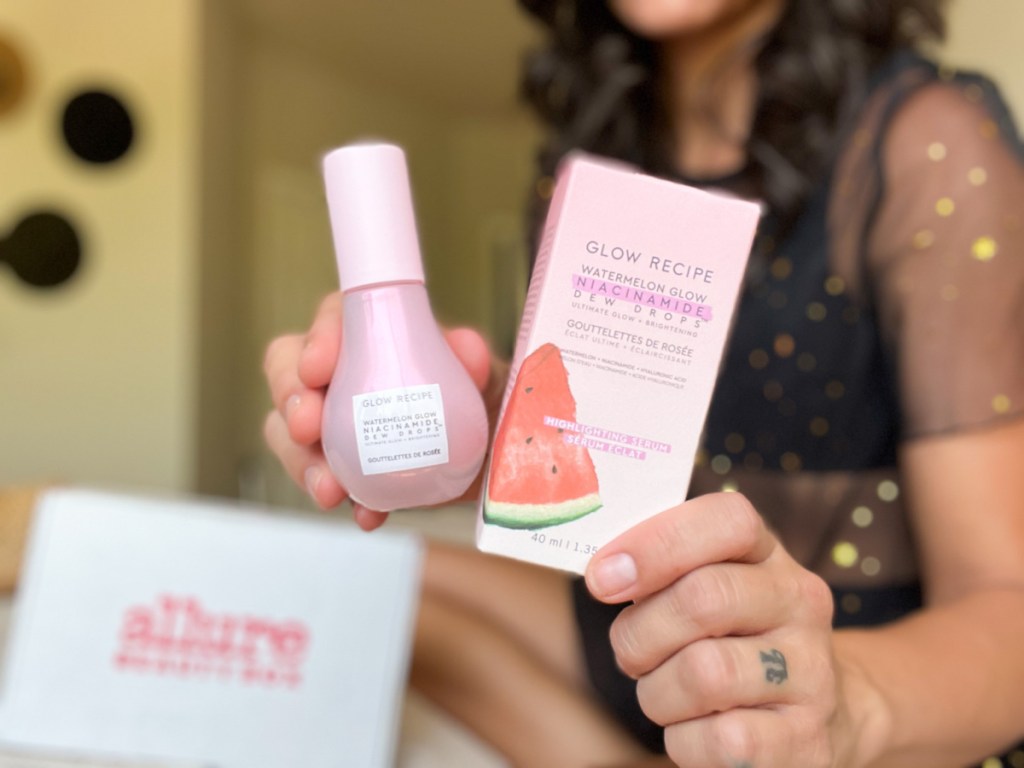 woman holding watermelon glow drops and box