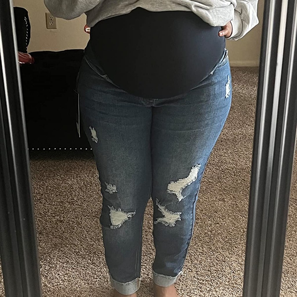 woman showing belly bump in mirror with jeans on
