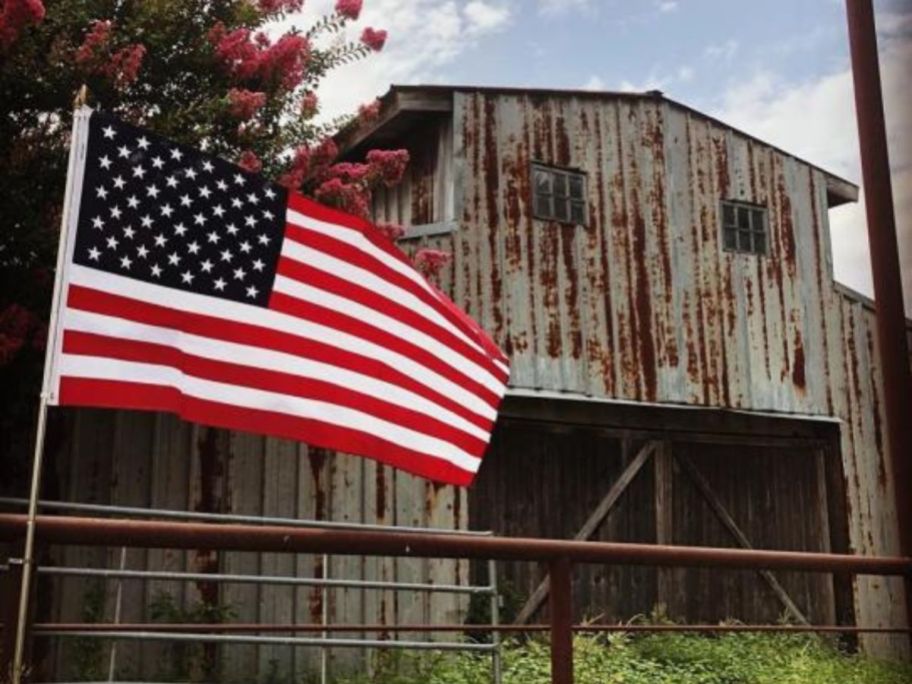 An american flag in front of a barn