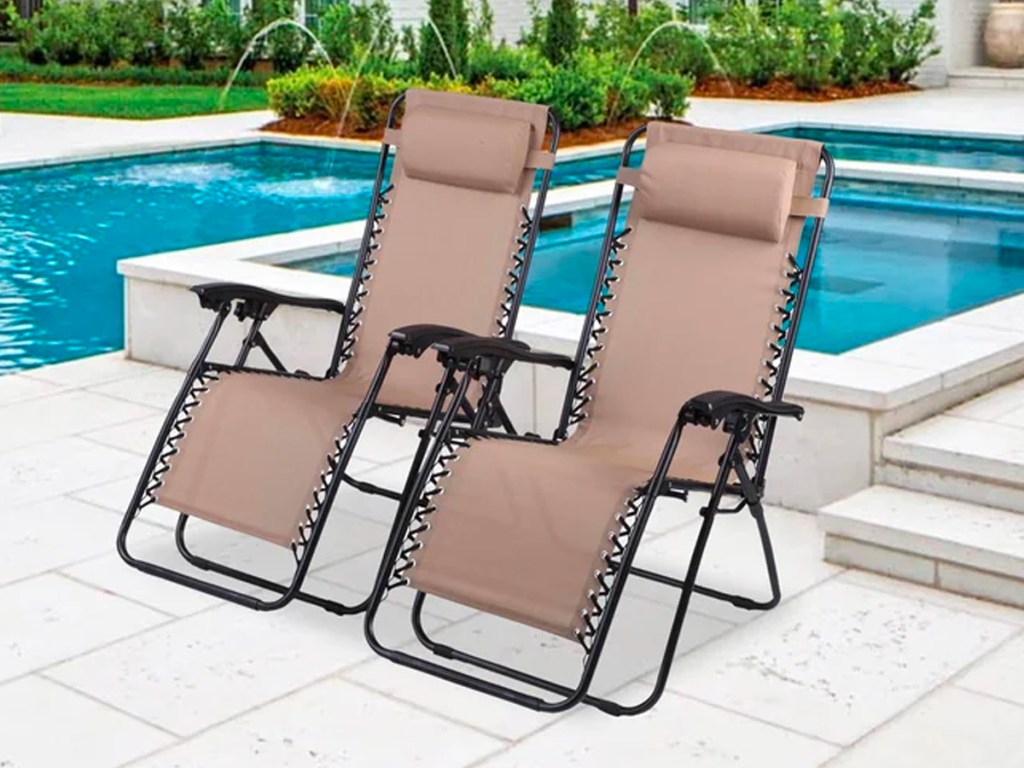 two beige gravity chairs near pool