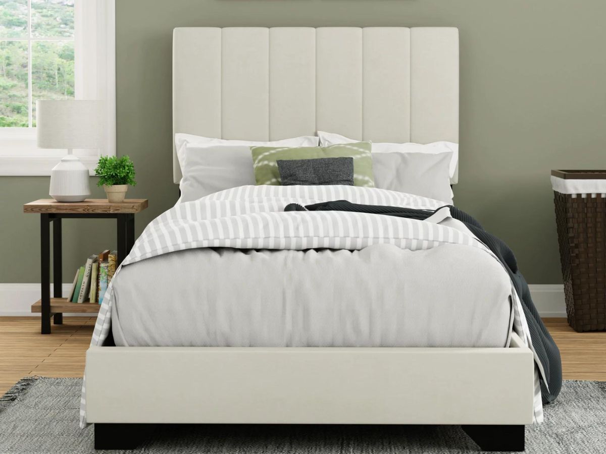 white upholstered bed frame in bedroom