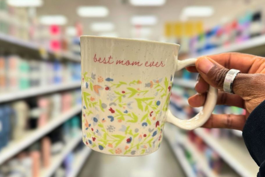 A womans hand holding a best mom ever coffee mug
