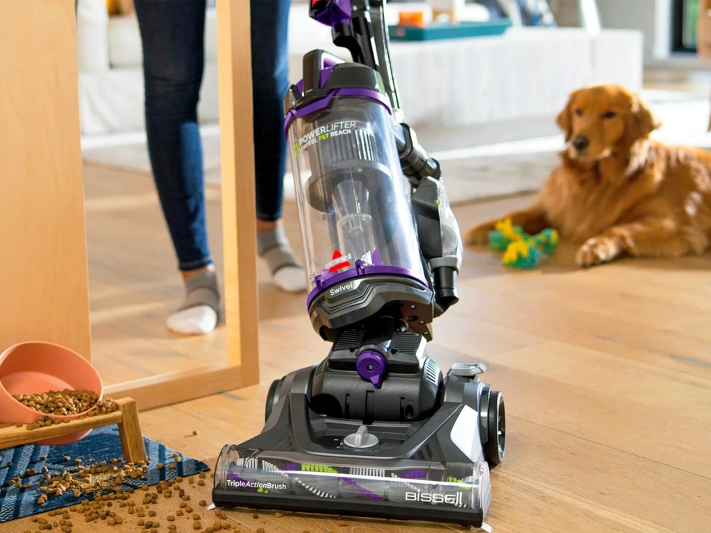 woman using bissell swivel pet vacuum on hardwood floor