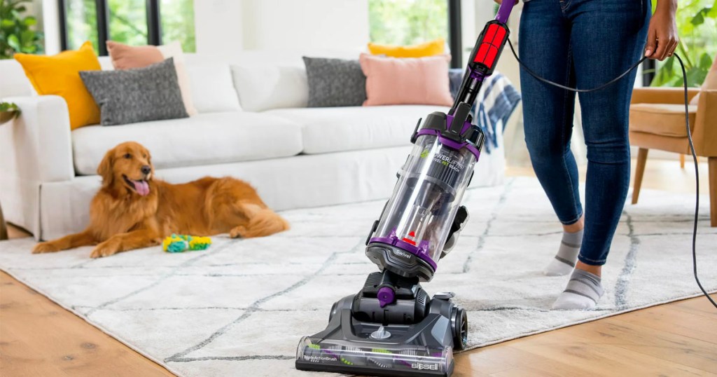 woman using bissell swivel pet vacuum on rug in living room