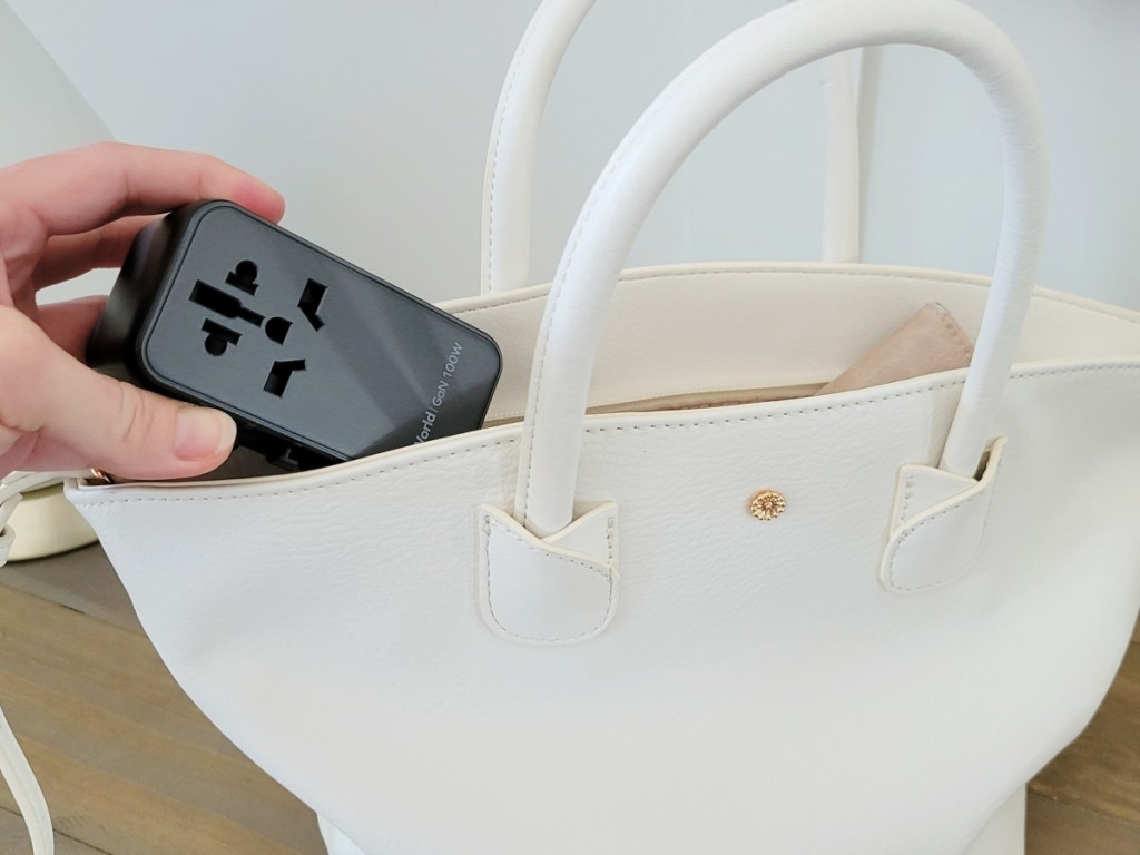 black international adapter going into woman's bag