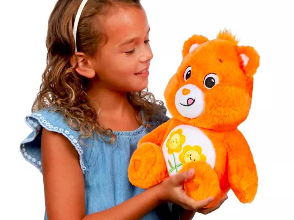 girl holding orange care bear
