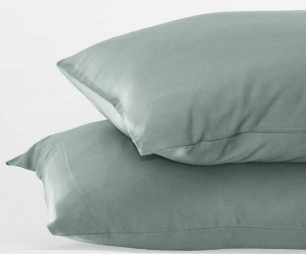 two sage green pillows stacked