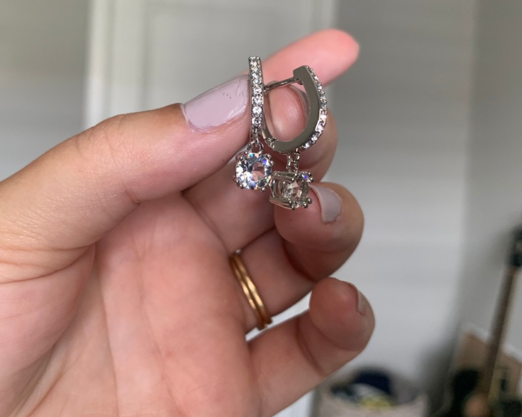 hand holding drop earrings