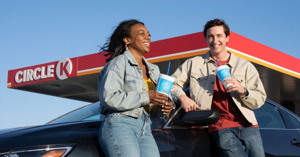 woman and man with circle k polar pops leaning on car