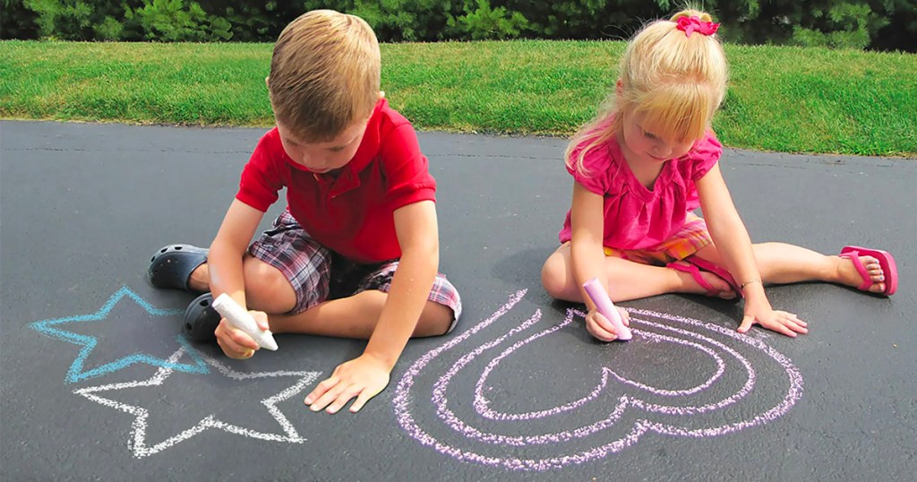 girl and boy drawing stars and hearts with sidewalk chalk