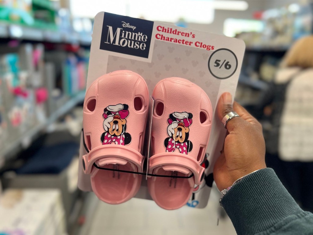hand holding pink disney minnie mouse clogs