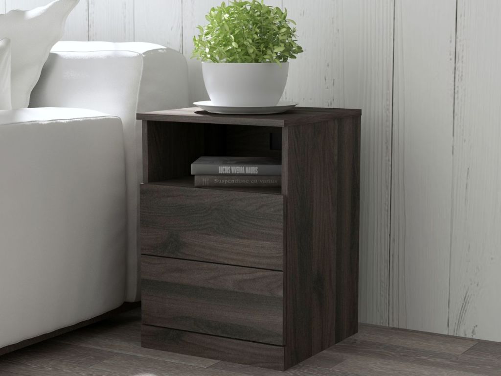 dark wood end table with plant on it next to bed