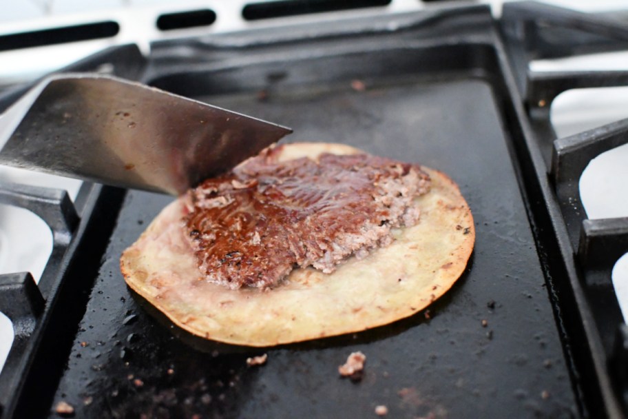 making a smash burger taco on blackstone style griddle